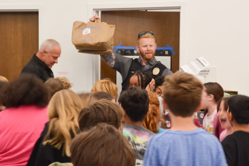 School Resource Officer Nick Yatsko holds up the stolen bag of candy found stashed in a utility closet. SUBMITTED PHOTOS